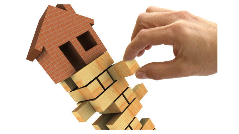 Picture of a housing sitting on blocks with hand removing a block
