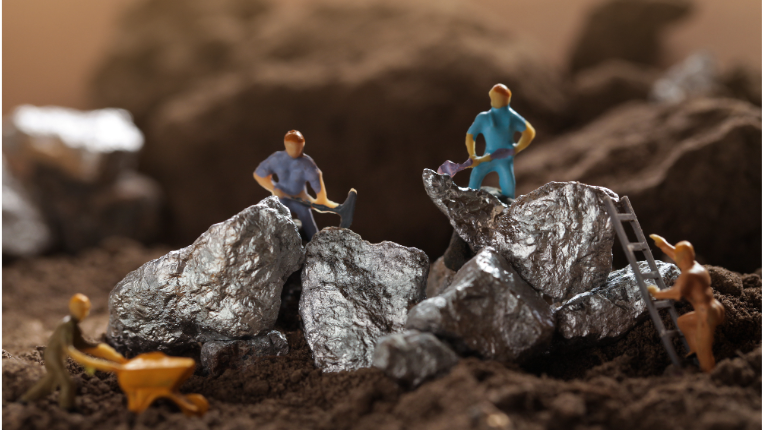 Toy miners standing on chunks of metal