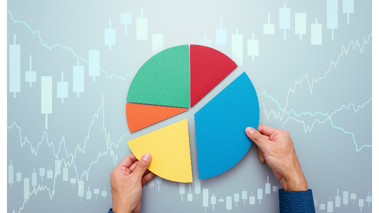 Picture of two hands holding a pie chart against a stock market graph