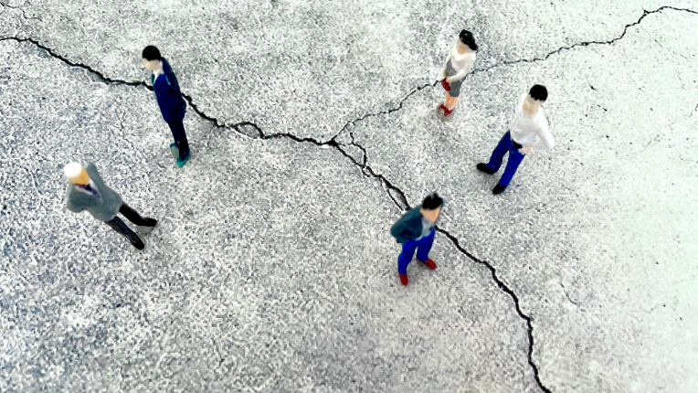 People standing on concrete looking at cracks