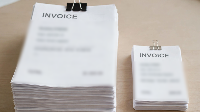 Tall and small invoice stacks with blurred text.