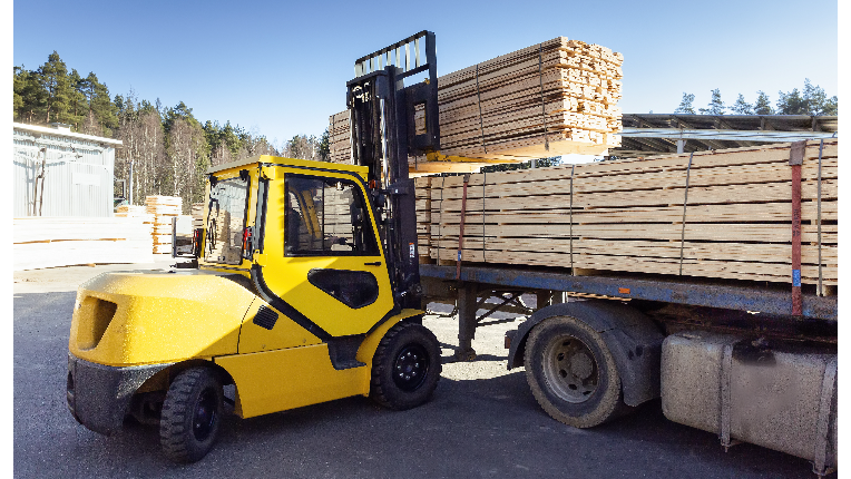 Forklift lifting lumber onto a truck